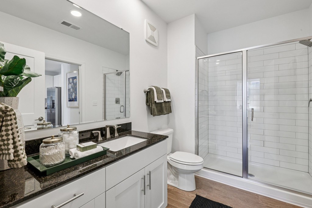 A bathroom with a toilet, sink, and shower.