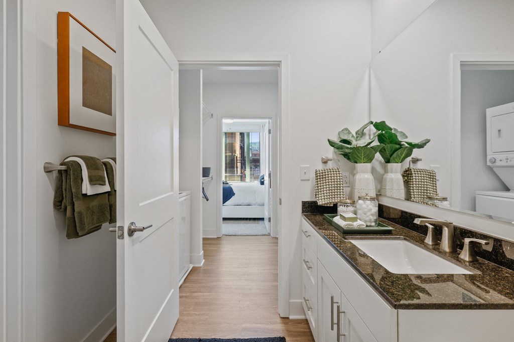 A bathroom with a white sink and a mirror above it.