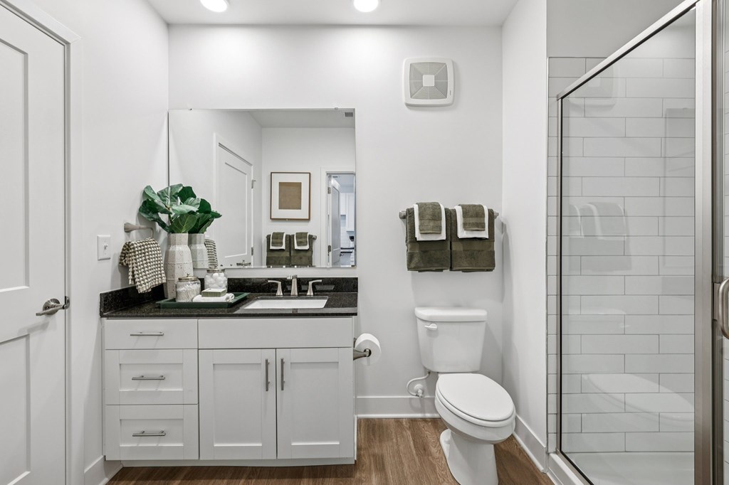 Bathroom at Contrast OTR apartments in Over-the-Rhine, Cincinnati with granite vanity, decorative accents, and full mirror.