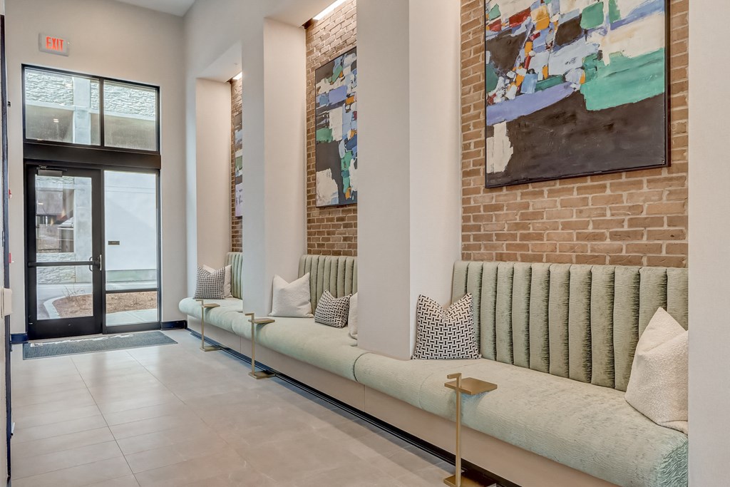 a living room with couches and a brick wall and a door