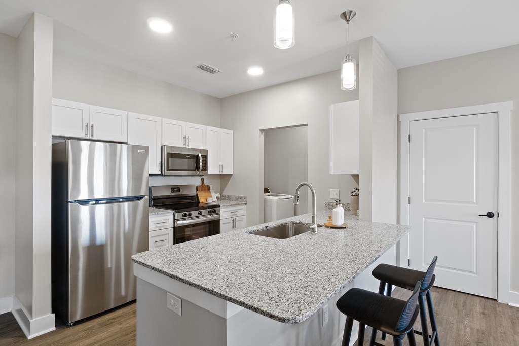 A kitchen with a granite countertop and stainless steel appliances.