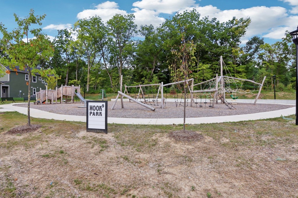 Outdoor playground at Nook Nine Apartments near wooded trails