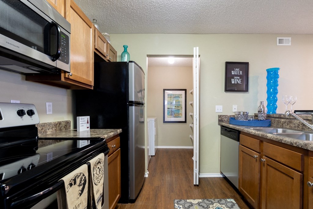Apartment kitchen with stove, microwave, and refrigerator in Blue Ash, OH.