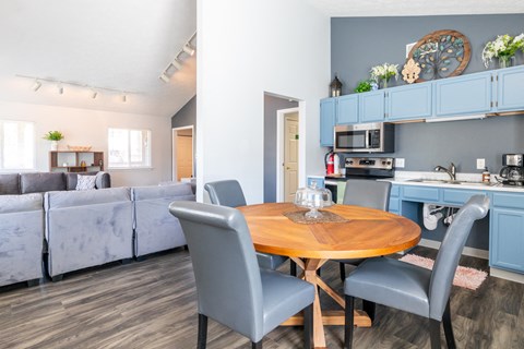 a kitchen and dining room with blue cabinets and a table and chairs