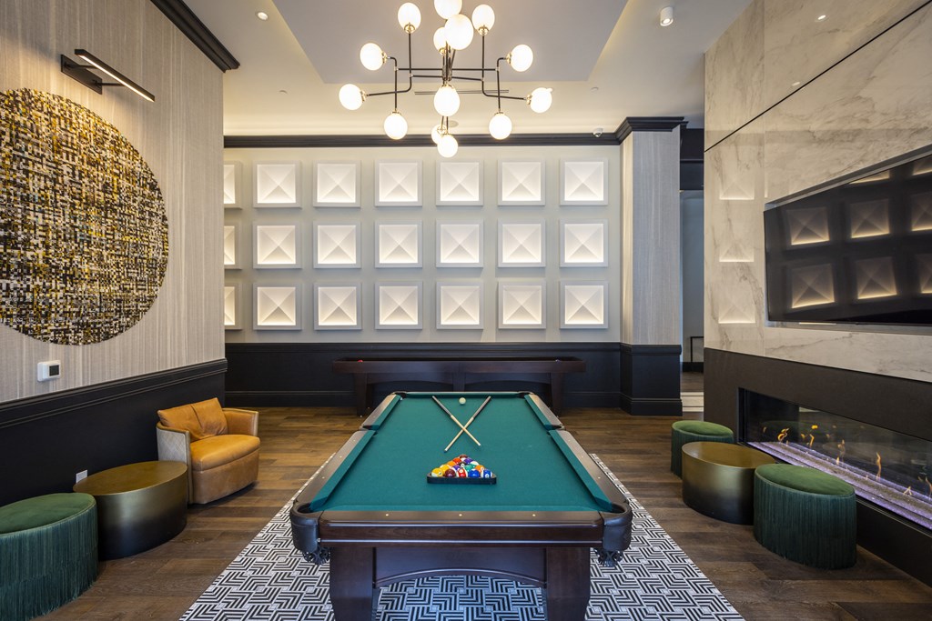 a pool table sits in the middle of a room with a fireplace and a chandelier