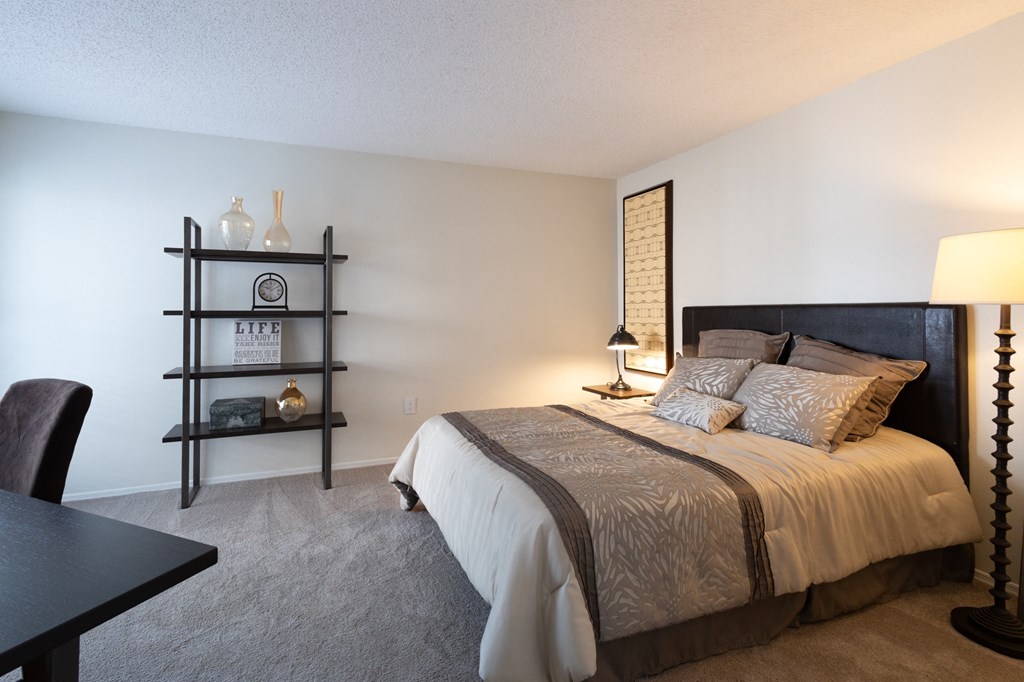 a bedroom with a large bed and a table with a chair