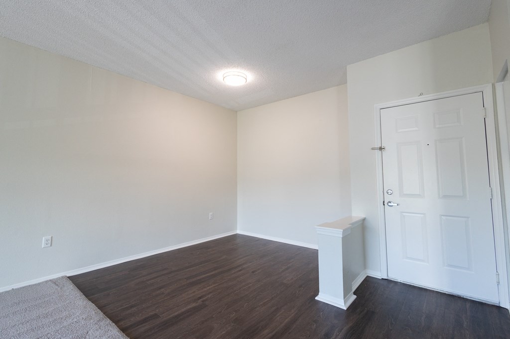 a dining room with vinyl plank hardwood flooring and apartment entry door