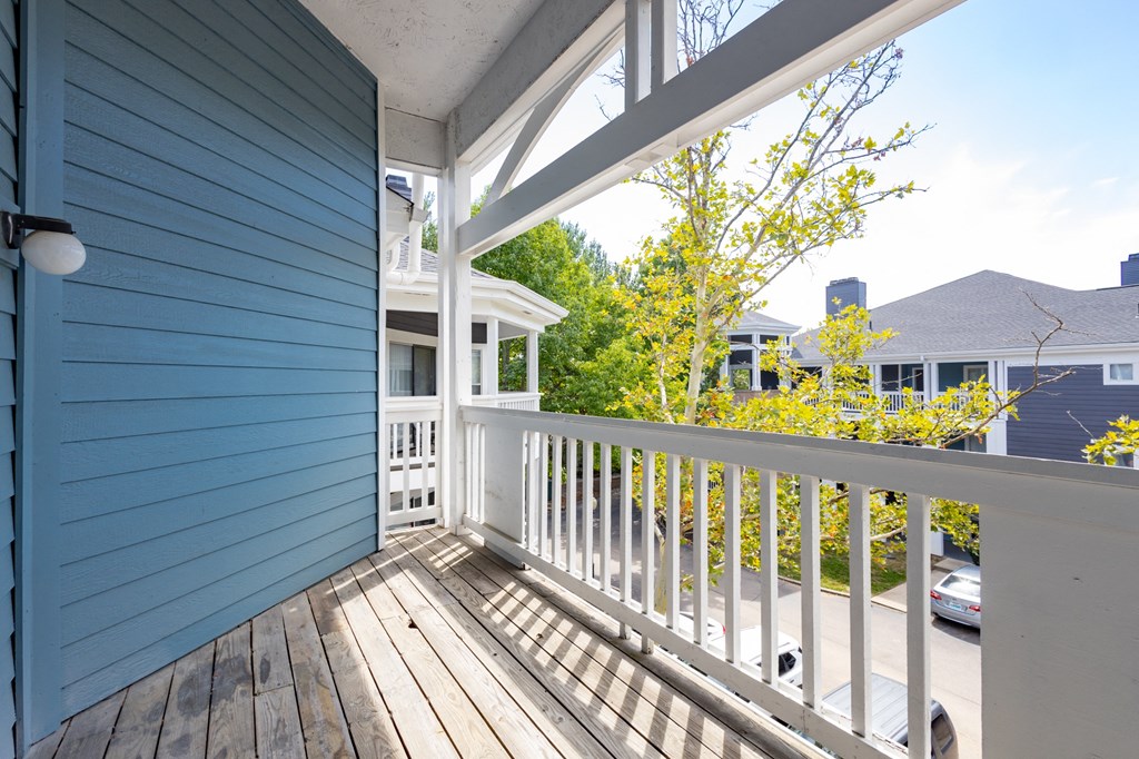 the view from the deck of a blue house with a white railing