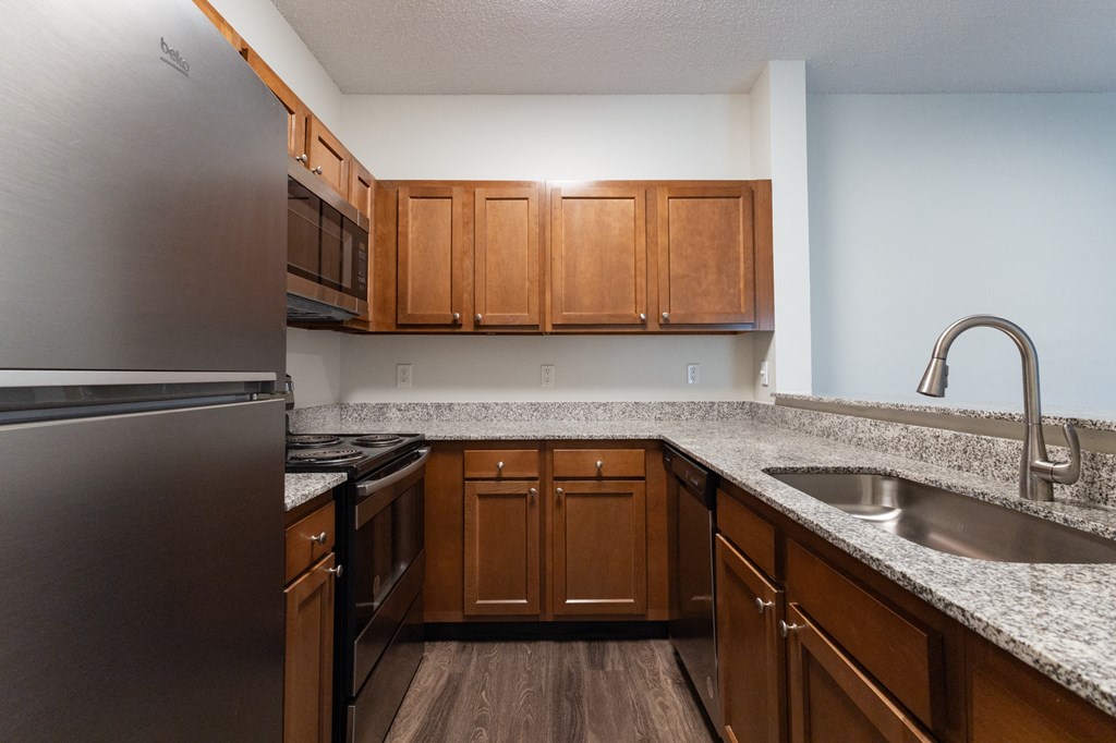 an empty kitchen with wooden cabinets and granite counter tops