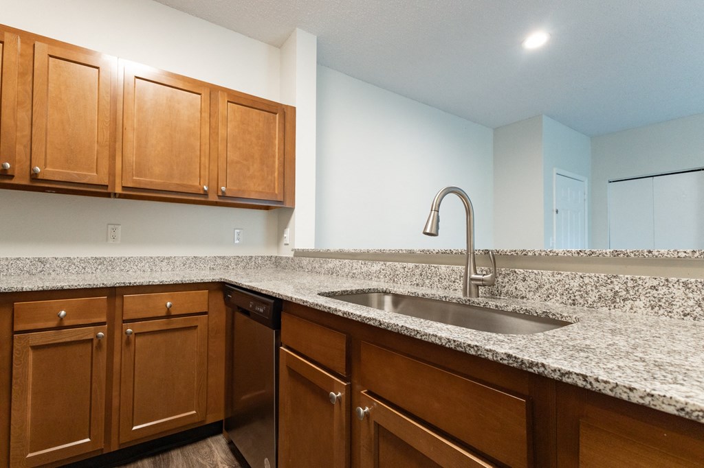 a kitchen with granite counter tops and wooden cabinets