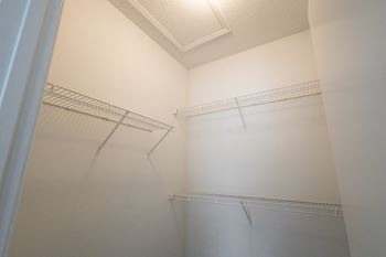 the walk in closet in the master bedroom of an apartment