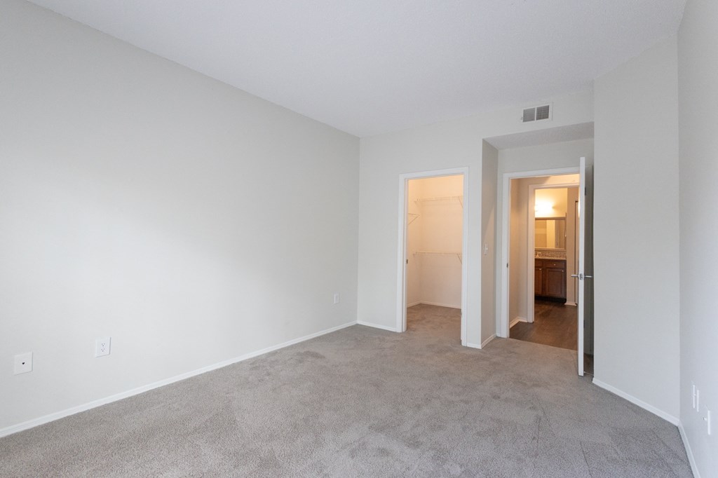 an empty living room with white walls and carpet