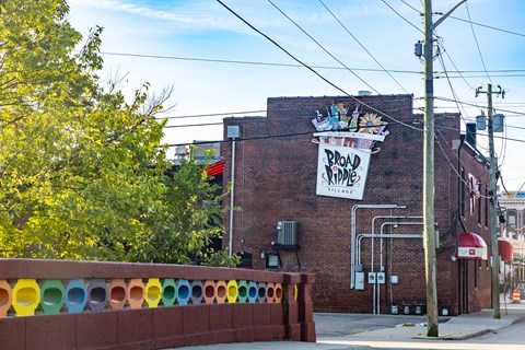 A red brick building with a banner that says Broad Village.