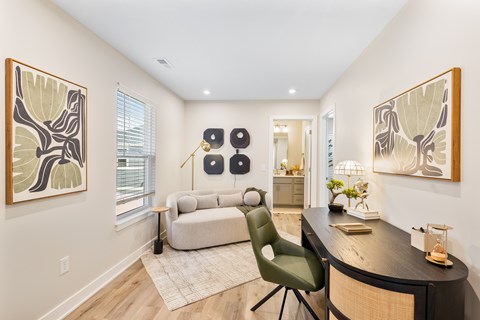 A modern living room with a green chair and a wooden desk.
