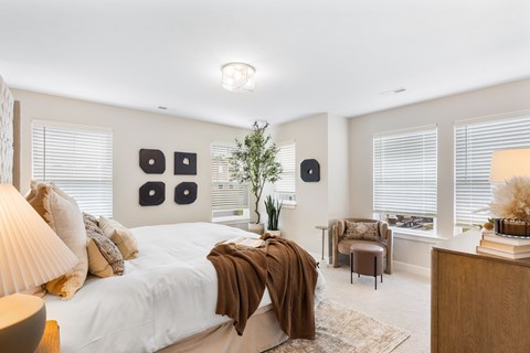 A bedroom with a large bed and a chair.
