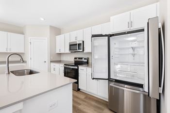 A modern kitchen with a refrigerator, sink, and cabinets. at Mural Lewis Center, Ohio, 43035