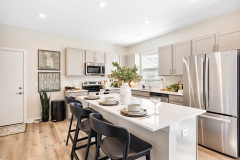 A modern kitchen with a dining table set for two.