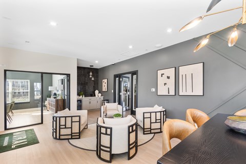 A modern dining area with a black table and white chairs.
