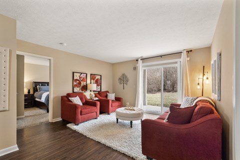 A living room with red couches and a white rug.