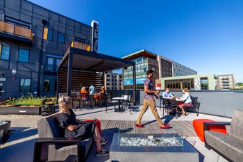 Outdoor entertainment areas in a rooftop space with grills, bar, seating, lights and art - Photo Gallery 43
