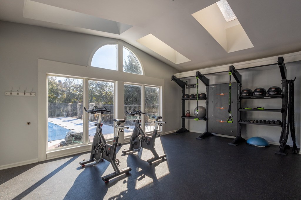 a gym with exercise equipment and a large window a gym with exercise equipment and a large window