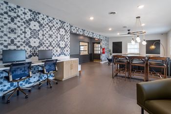 a conference room with desks and chairs and a table with chairs