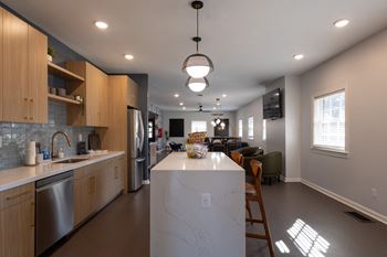 a kitchen with a large island and a living room with a table and chairs