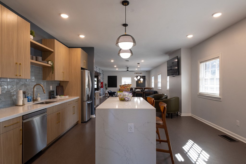 a kitchen with a large island and a living room with a table and chairs