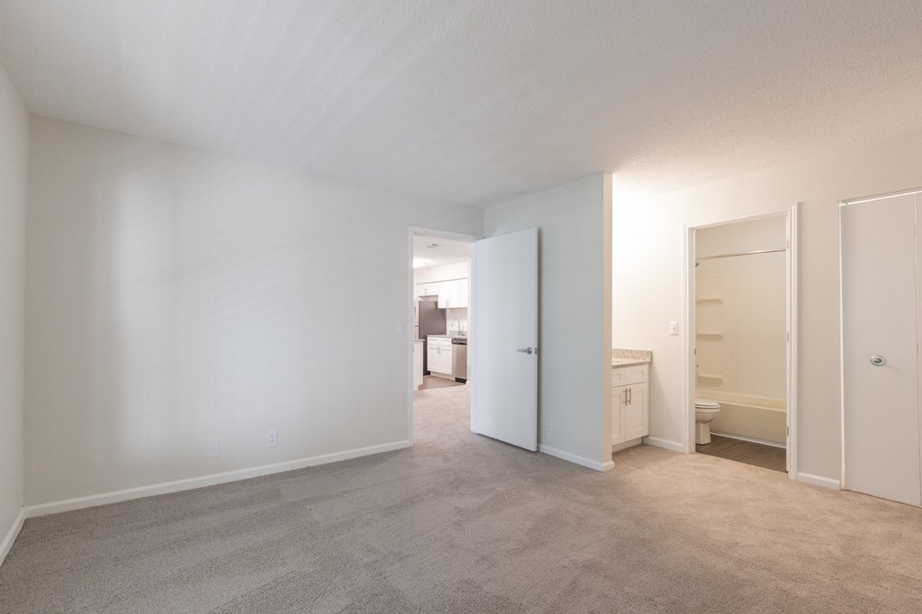 a bedroom with white walls and carpet