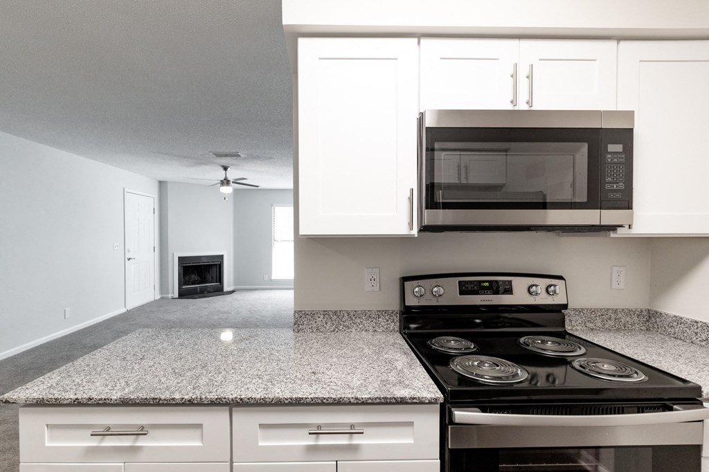 a kitchen with white cabinets and a black stove top oven