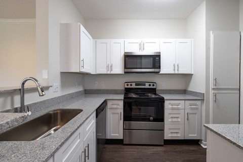 a kitchen with white cabinets and stainless steel appliances