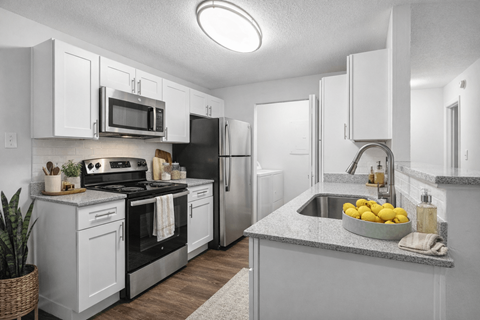 A kitchen with white cabinets and a black stove top oven.
