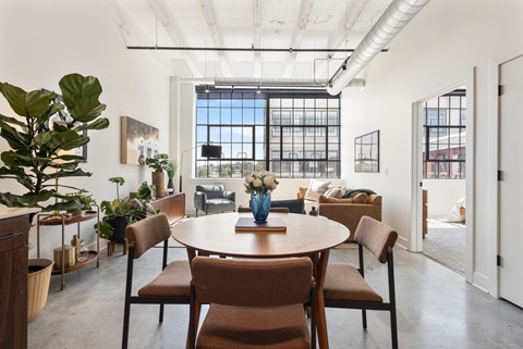 Loft dining table and living area beneath exposed white beams