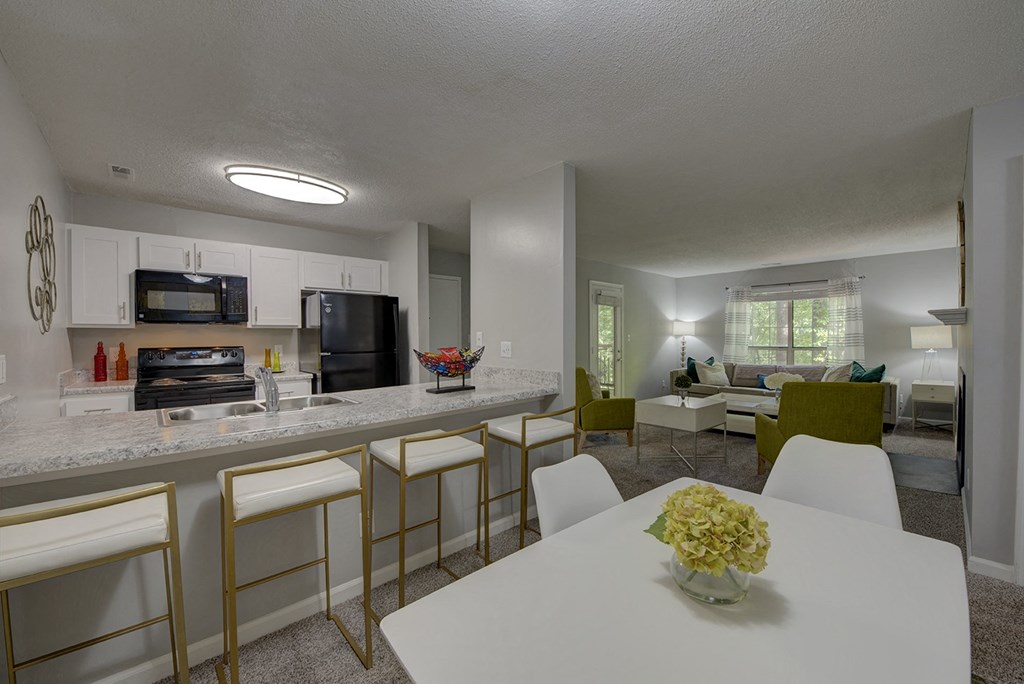 A white dining table with a vase of flowers on it.