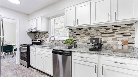 an open kitchen with white cabinets and a counter top