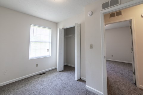 a bedroom with a large window and a closet