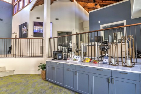 a kitchen with blue cabinets and a counter with coffee machines