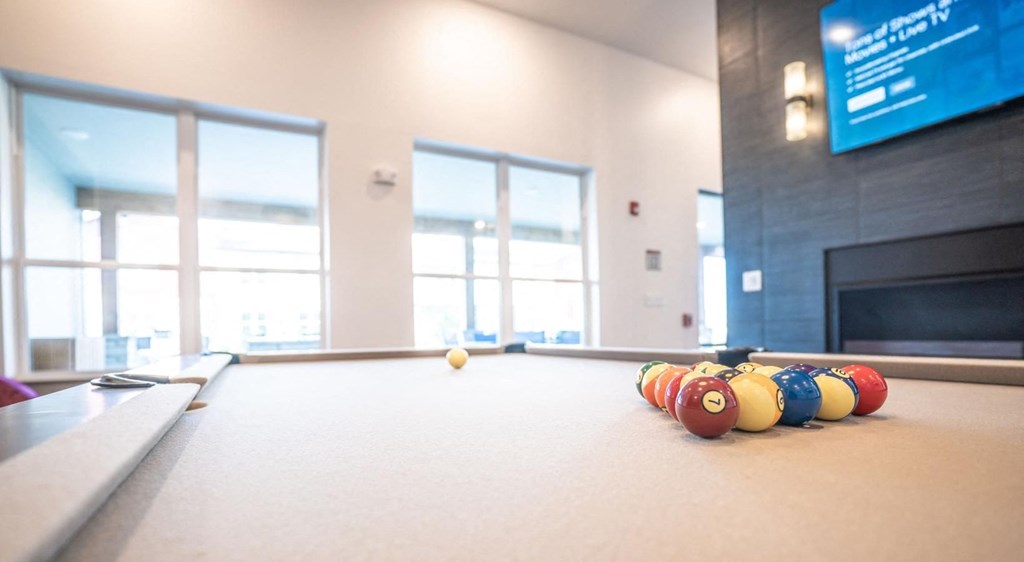a billiards room with a pool table and colorful balls