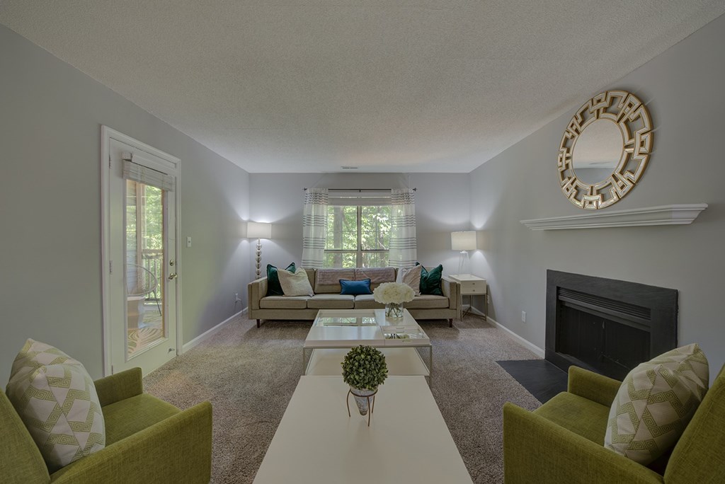 A living room with a fireplace and a mirror on the wall.
