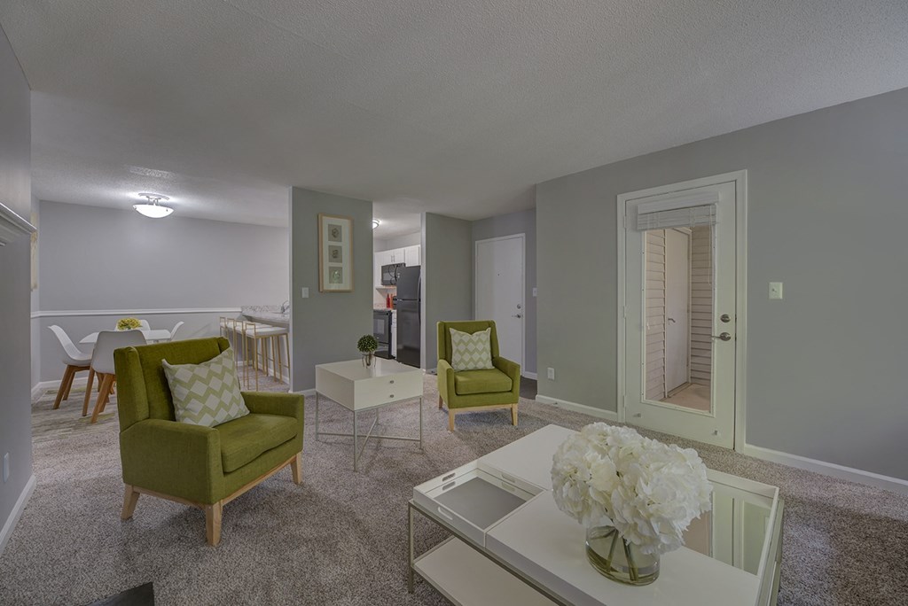 A living room with a green chair and a white coffee table.