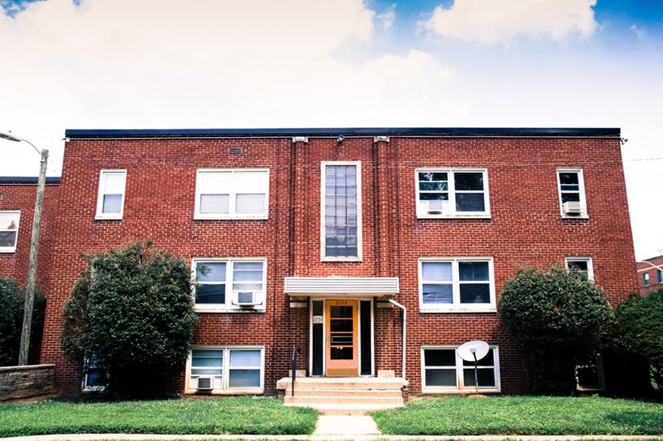 the front of a red brick building with a yellow door