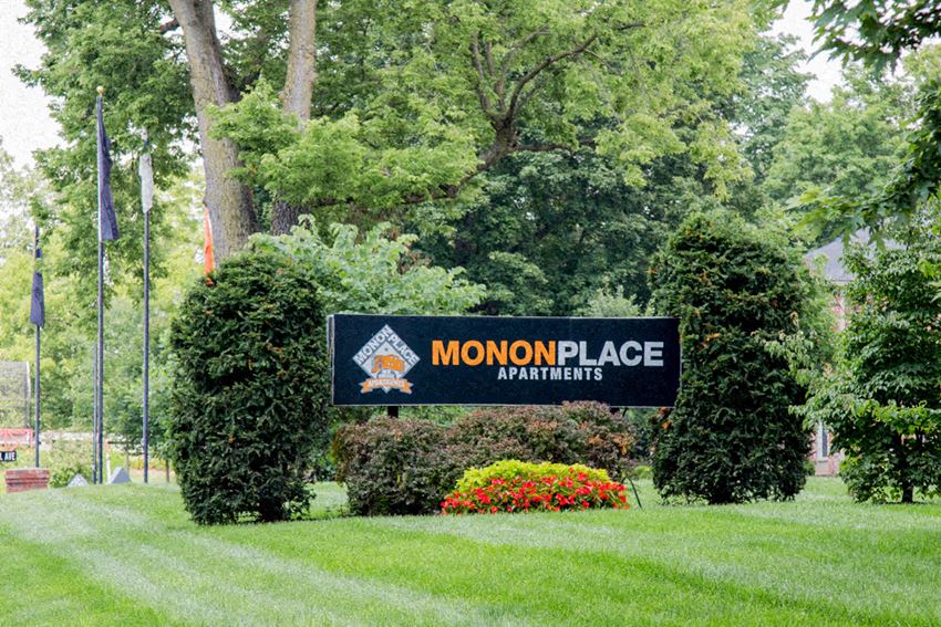a sign on a lawn with trees in the background