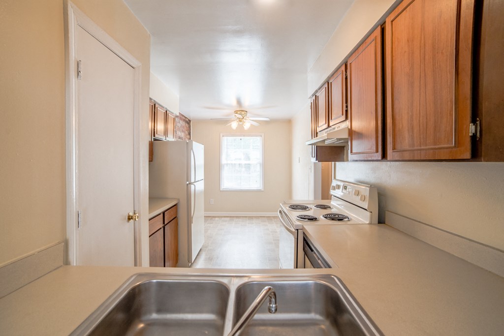 the view of a kitchen with a sink and a refrigerator
