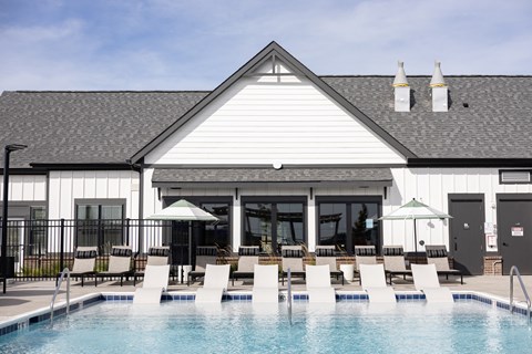 Resort-style swimming pool with in-water lounge chairs and poolside seating at Montage West Lafayette apartments in West Lafayette, IN.