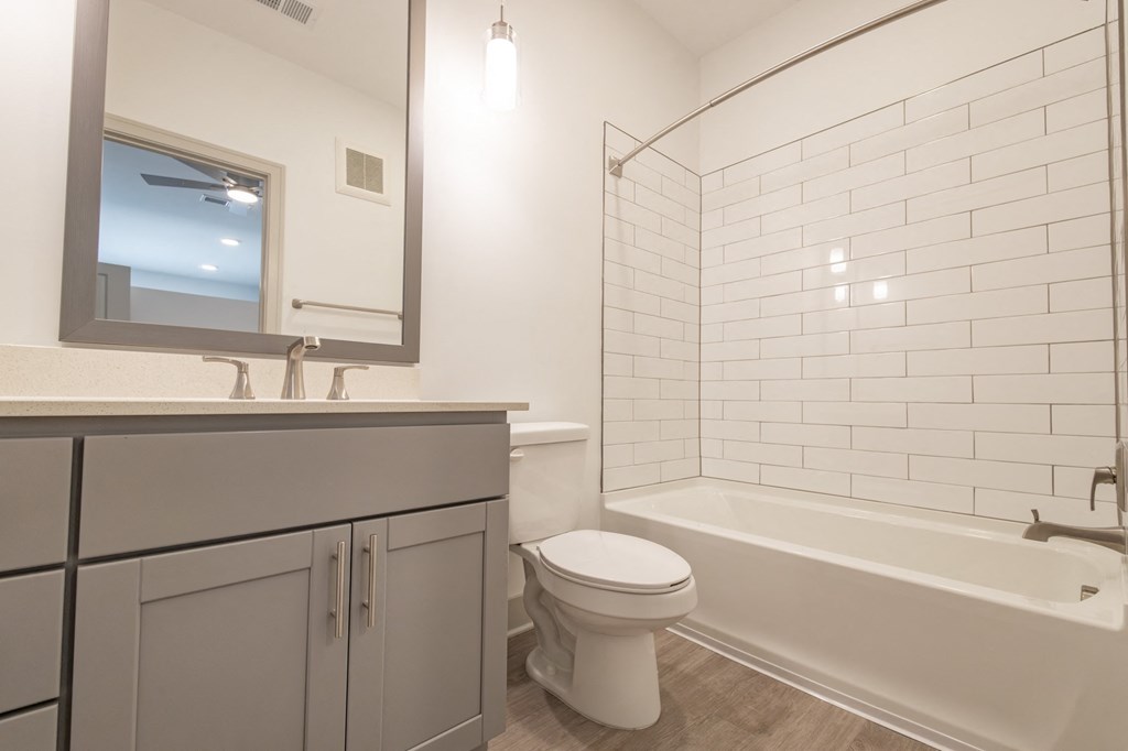 a bathroom with a toilet and a tub and a sink