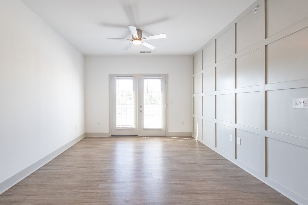 an empty room with white walls and a ceiling fan