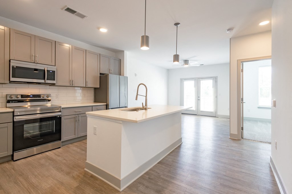 an open kitchen and living room with an island and stainless steel appliances