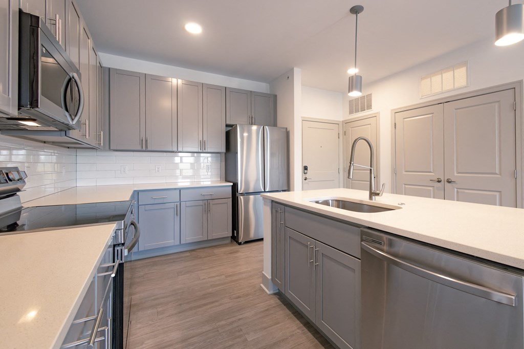 a kitchen with stainless steel appliances and white counter tops