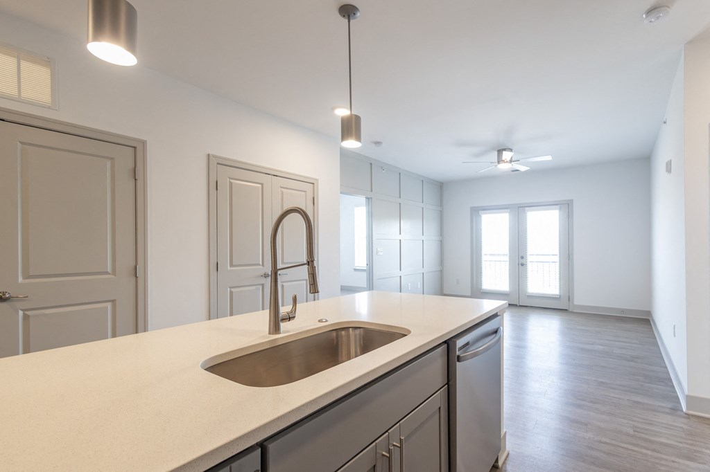 an empty kitchen with white cabinets and a sink