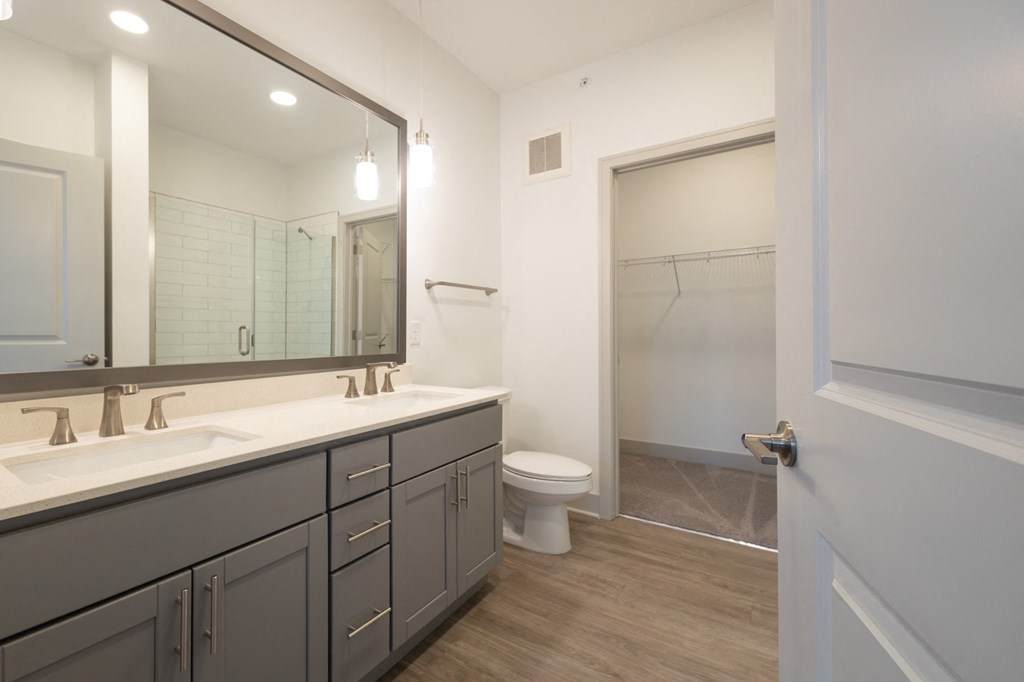 a bathroom with a large mirror and a toilet and a shower